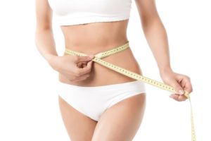 stock photo woman measuring her waistline